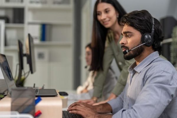 Asian professional businessman using laptop computer video call in office. Attractive handsome professional male employee worker sitting on table working and talking with customer at night in company.
